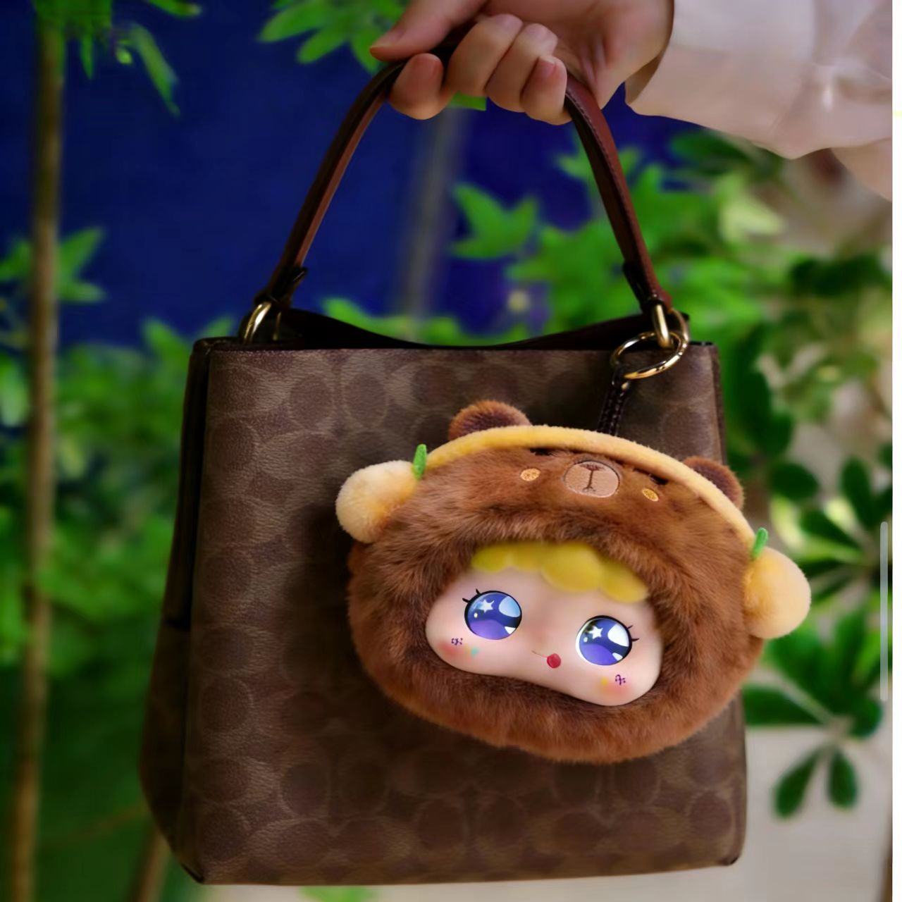 An AI capybara plushie dangles from a woman's handbag as a charm